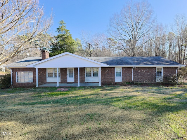 single story home featuring covered porch and a front yard