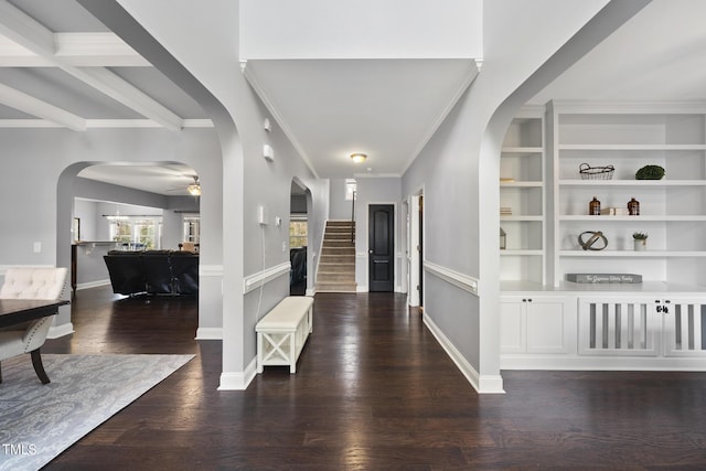 foyer entrance featuring crown molding, beam ceiling, dark wood-type flooring, and ceiling fan