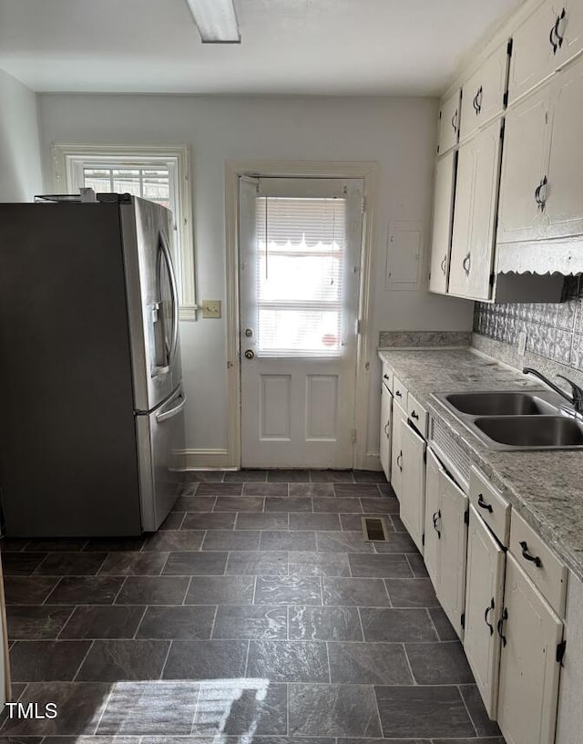 kitchen featuring white cabinets, sink, plenty of natural light, and stainless steel fridge with ice dispenser