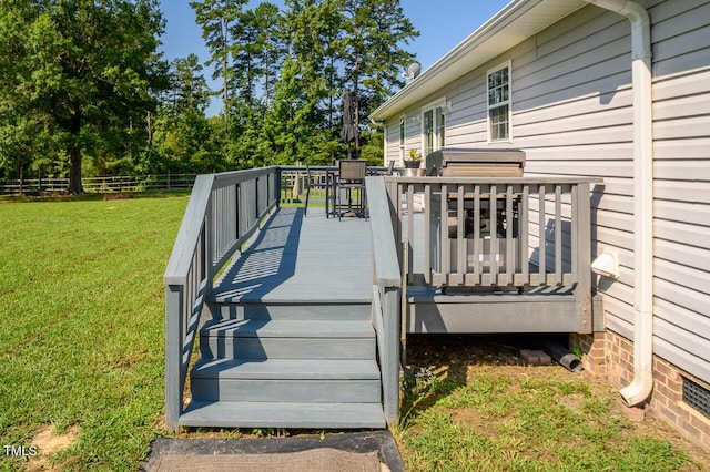 deck featuring a grill and a yard