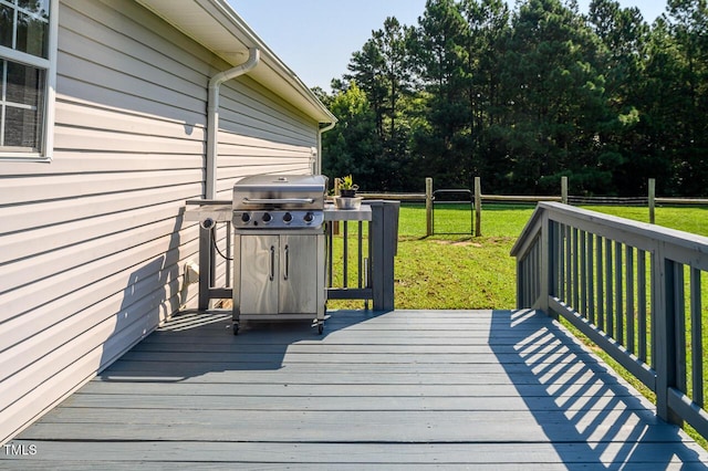 wooden deck with area for grilling and a yard