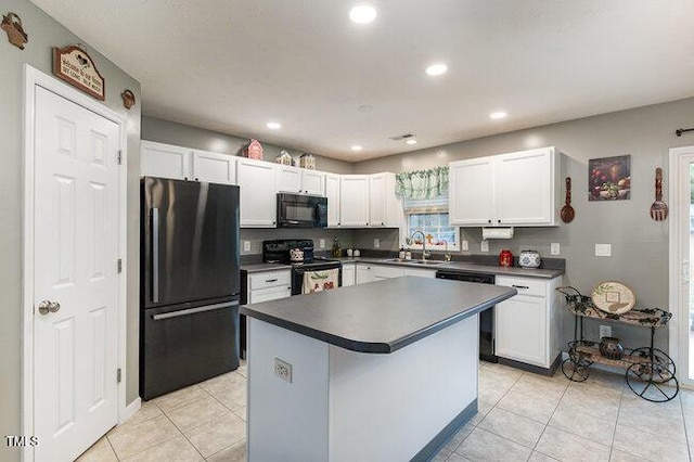 kitchen featuring light tile patterned floors, dark countertops, black appliances, white cabinetry, and a sink