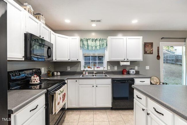 kitchen featuring black appliances, a sink, visible vents, and white cabinetry