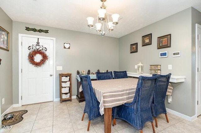 dining space with an inviting chandelier, baseboards, and light tile patterned flooring