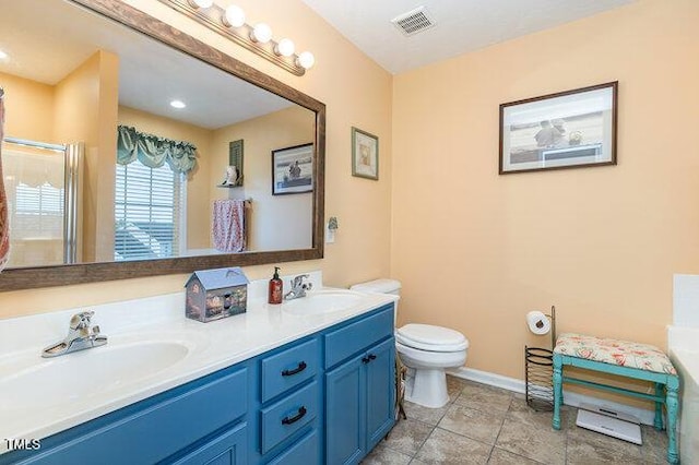 bathroom featuring visible vents, a sink, toilet, and double vanity