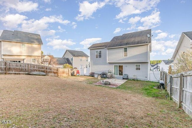 rear view of house featuring a lawn, a patio area, and a fenced backyard