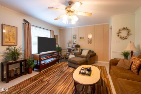 living room featuring ornamental molding and ceiling fan