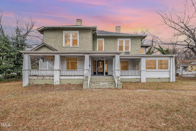 view of front facade with covered porch and a yard