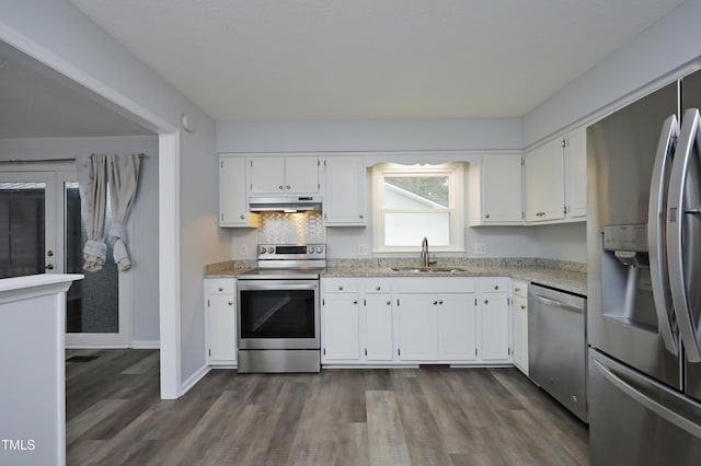 kitchen with sink, dark wood-type flooring, stainless steel appliances, tasteful backsplash, and white cabinets