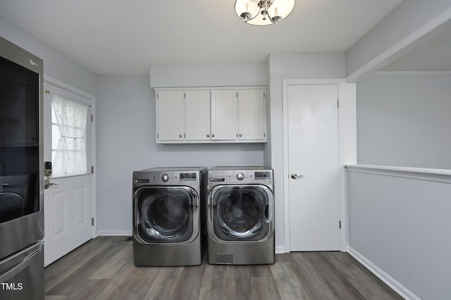 clothes washing area with separate washer and dryer, dark wood-type flooring, and cabinets