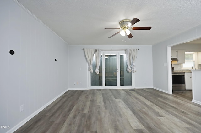 unfurnished living room with ceiling fan, french doors, wood-type flooring, and a textured ceiling