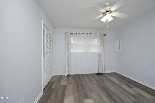 unfurnished bedroom featuring ceiling fan, dark hardwood / wood-style flooring, a textured ceiling, and a closet