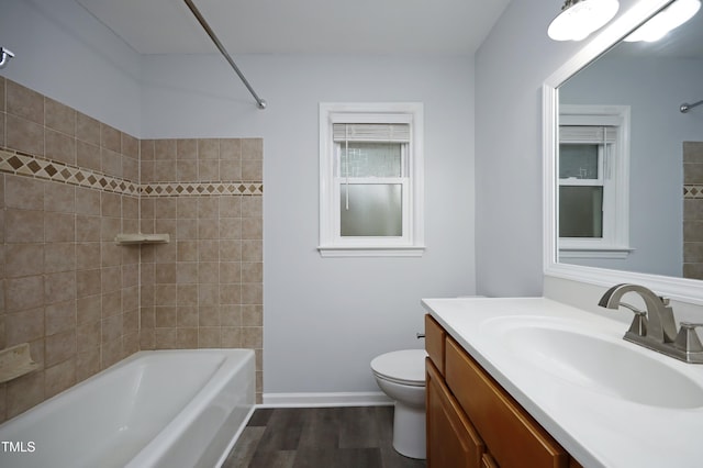 full bathroom with hardwood / wood-style floors, vanity, toilet, and tiled shower / bath combo