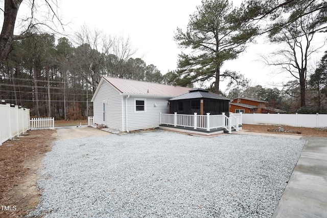 rear view of property featuring a gazebo and a deck