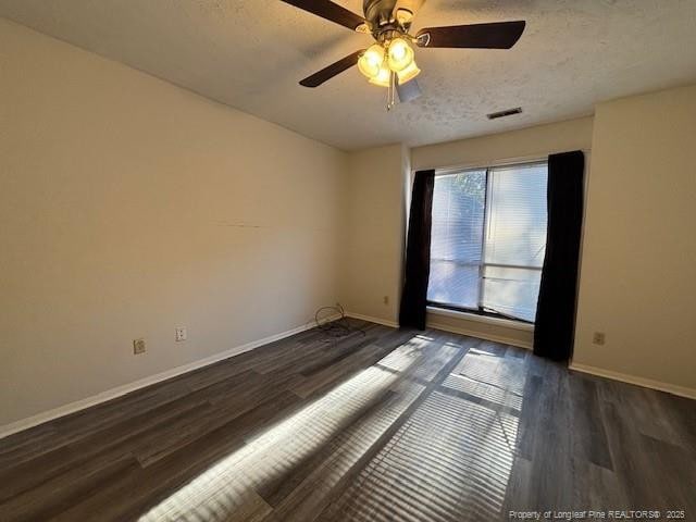 empty room with a textured ceiling, ceiling fan, and dark wood-type flooring