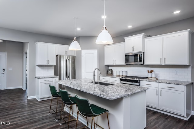 kitchen with a kitchen island with sink, sink, white cabinets, and appliances with stainless steel finishes