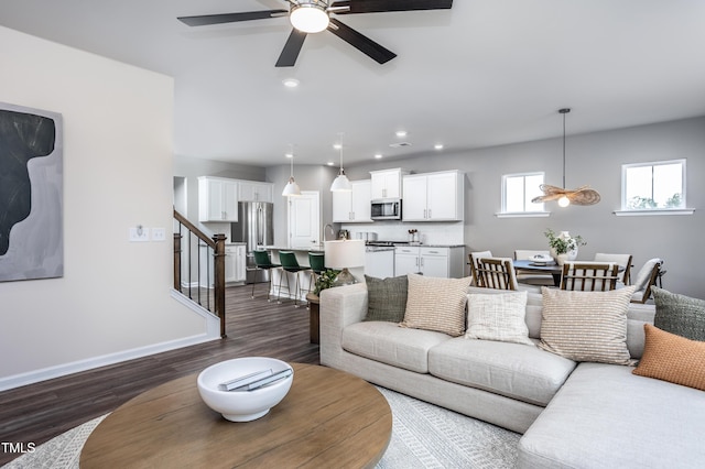 living room with dark hardwood / wood-style flooring and ceiling fan