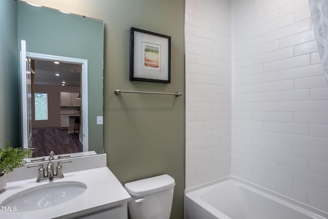 full bathroom featuring washtub / shower combination, vanity, and toilet