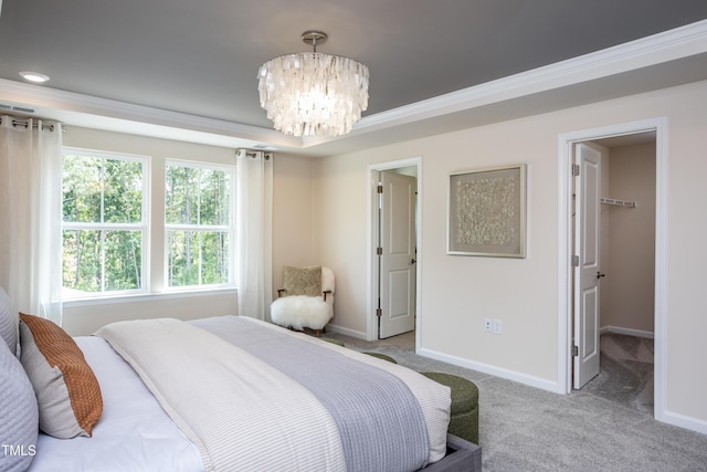 bedroom featuring a walk in closet, ornamental molding, light colored carpet, and an inviting chandelier