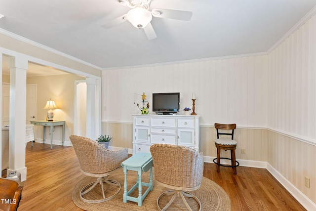 sitting room with light hardwood / wood-style floors, ceiling fan, and ornamental molding