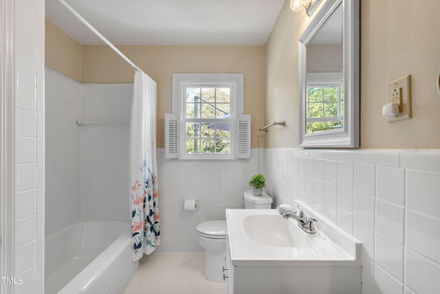 full bathroom featuring vanity, shower / bathtub combination with curtain, toilet, and tile walls