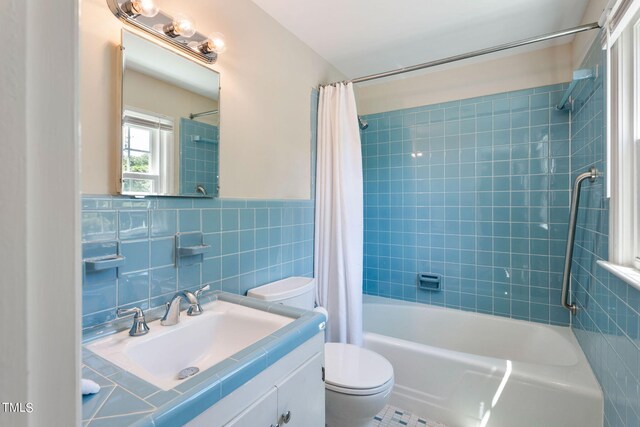 full bathroom featuring vanity, shower / bath combo with shower curtain, tile walls, tile patterned flooring, and toilet