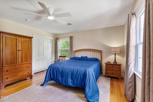 bedroom with ceiling fan, a closet, and light hardwood / wood-style floors