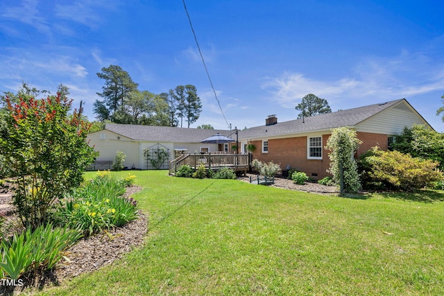 back of property with a lawn and a wooden deck