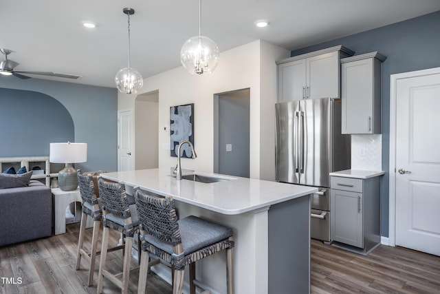 kitchen with ceiling fan, sink, stainless steel fridge, pendant lighting, and gray cabinets