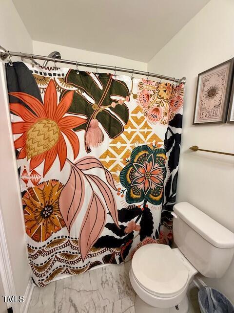 bathroom featuring a shower with shower curtain and toilet