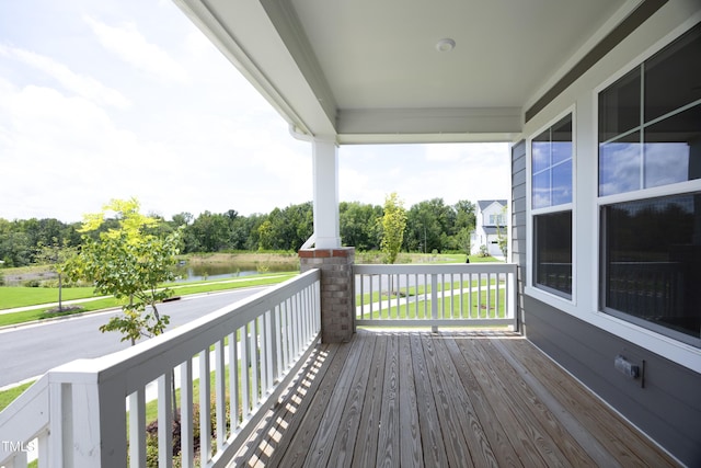 deck with a water view and a porch