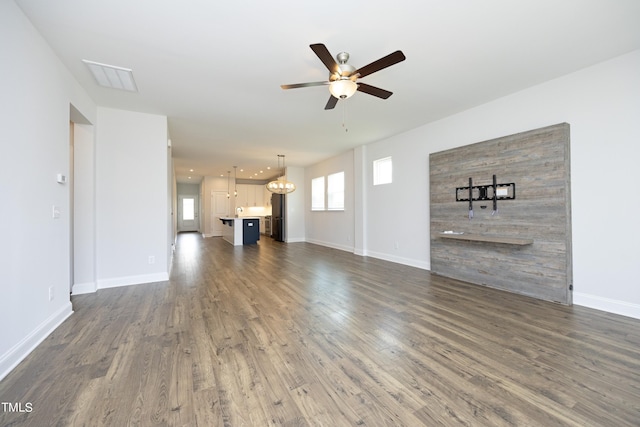 unfurnished living room featuring ceiling fan and dark wood-type flooring