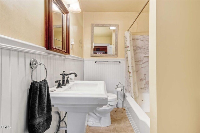 bathroom featuring shower / bath combo with shower curtain and sink