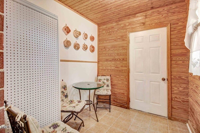 sitting room featuring wooden ceiling and wood walls