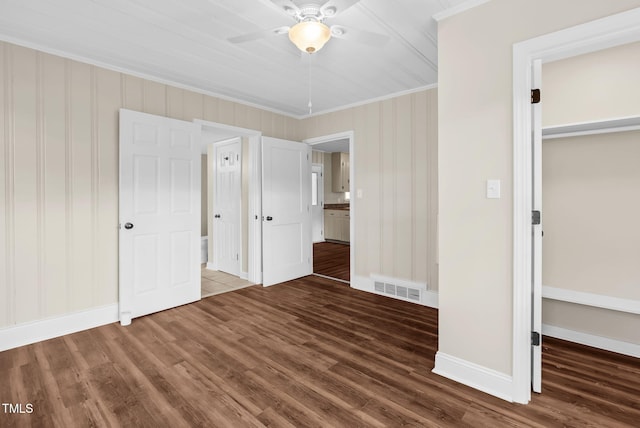 unfurnished bedroom with dark hardwood / wood-style flooring, ceiling fan, a closet, and crown molding