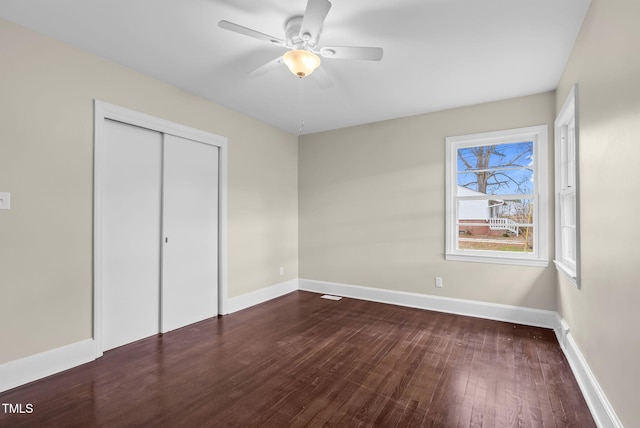 unfurnished bedroom with ceiling fan, a closet, and wood-type flooring