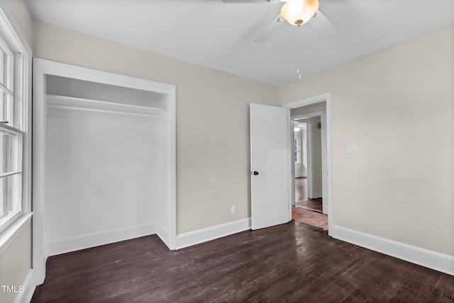 unfurnished bedroom featuring dark hardwood / wood-style flooring, a closet, and ceiling fan