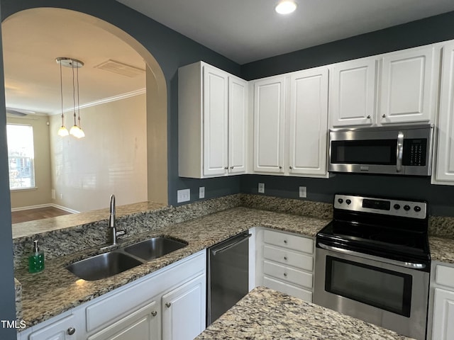 kitchen featuring sink, stone countertops, pendant lighting, stainless steel appliances, and white cabinets