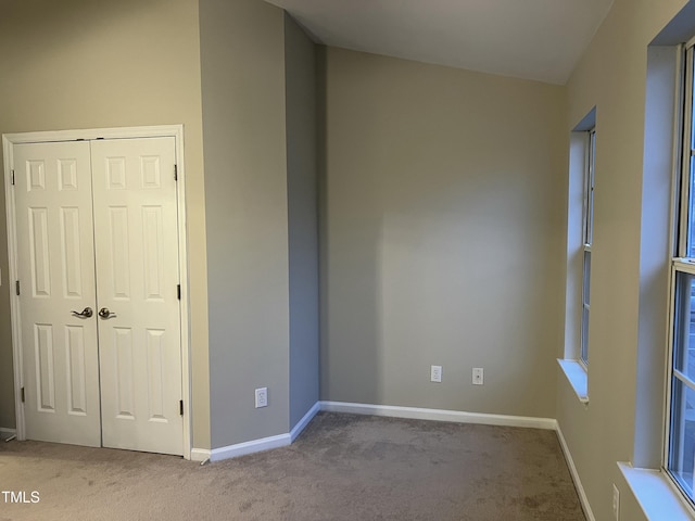 unfurnished bedroom featuring light colored carpet and a closet