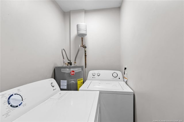 clothes washing area featuring washer and clothes dryer and water heater