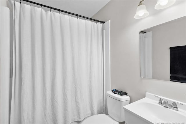 bathroom featuring a shower with curtain, toilet, and vanity