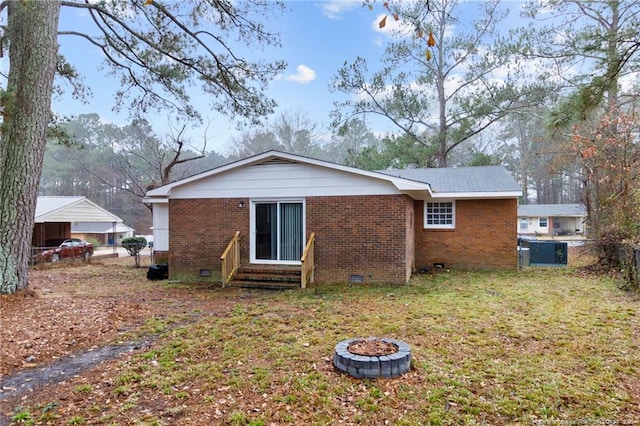 rear view of house featuring a yard and a fire pit