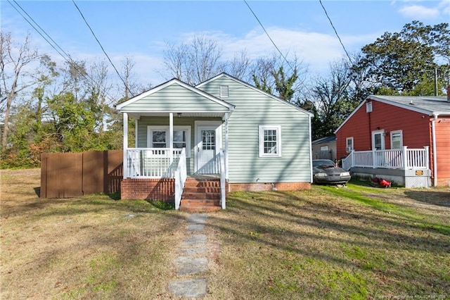 bungalow-style home featuring covered porch and a front yard