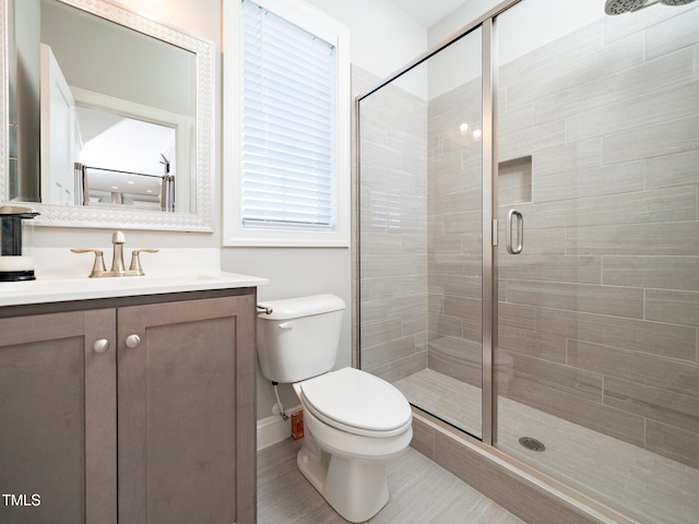 bathroom featuring vanity, toilet, and walk in shower