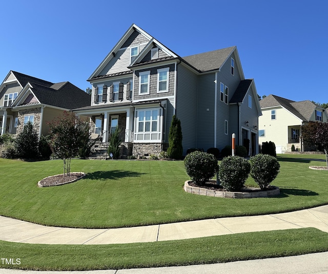 craftsman-style house featuring a front lawn, a porch, and a garage