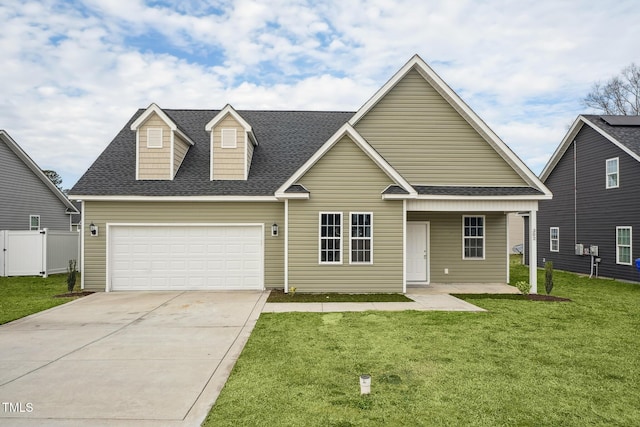 view of front of home featuring a front yard, a garage, and covered porch