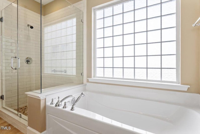 bathroom featuring a stall shower and a garden tub