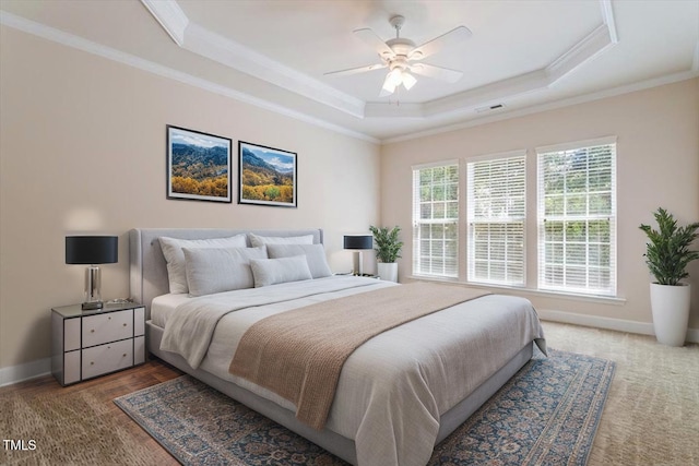 bedroom with crown molding, a raised ceiling, baseboards, and visible vents