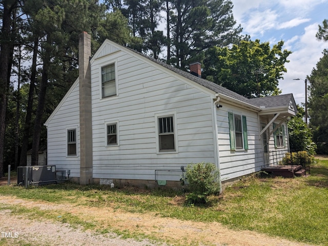 view of property exterior featuring a lawn and cooling unit