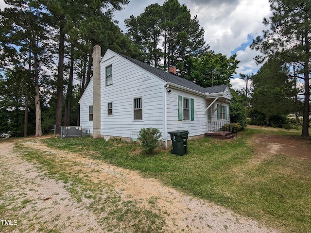 view of home's exterior with a lawn and central air condition unit